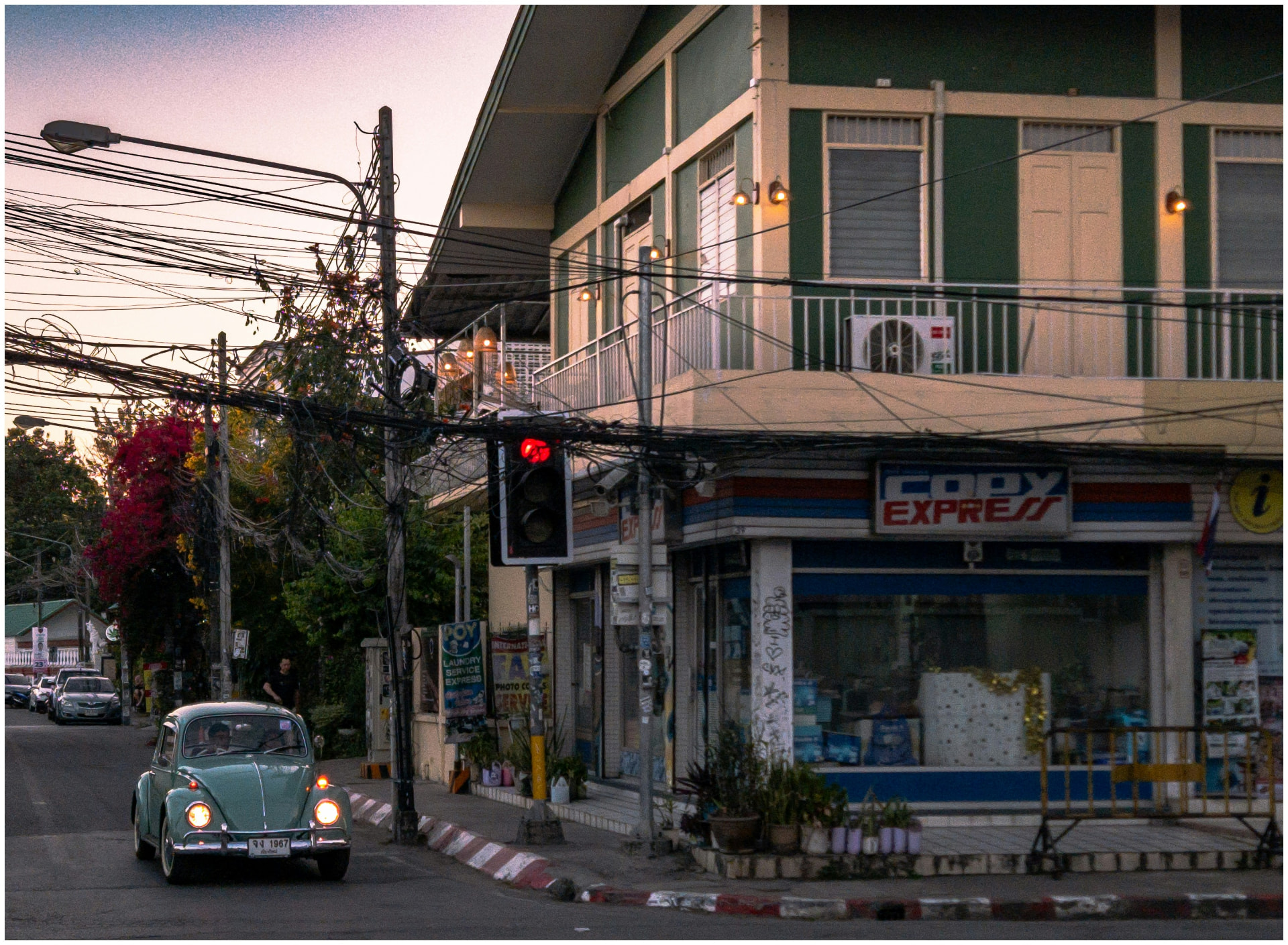 A quiet Chiang Mai street at dusk with a vintage car and local shopfronts
